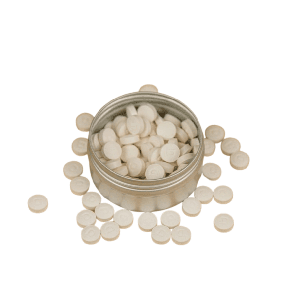 Une boîte biodégradable remplie de Dentifrice à croquer Bio – 120 pastilles à la Menthe sur une surface blanche.