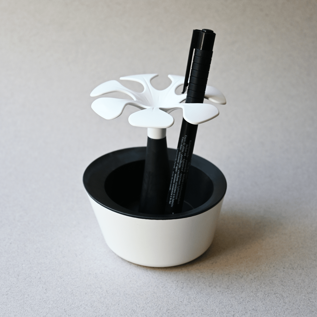 Un pot de crayons en forme de fleurs biodégradable et français rempli de fleurs, avec un stylo dedans.
