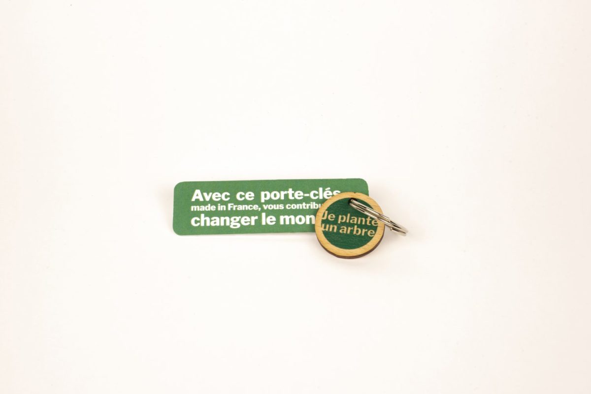 Un porte-clés rond en bois personnalisable et français en vert avec un message gravé dessus.
