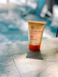 tube de crème solaire au bord d'une piscine