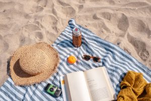 objets de vacances posés sur une serviette sur la plage