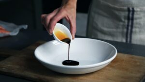 personne vidant du vinaigre dans une assiette