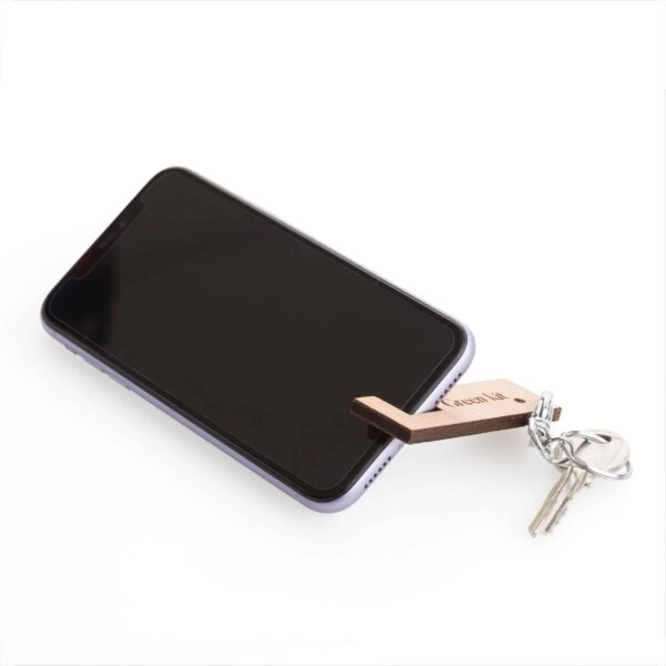 Un téléphone portable auquel est attaché un Porte-Clés avec Support de Téléphone en Bois Fin & Personnalisable.