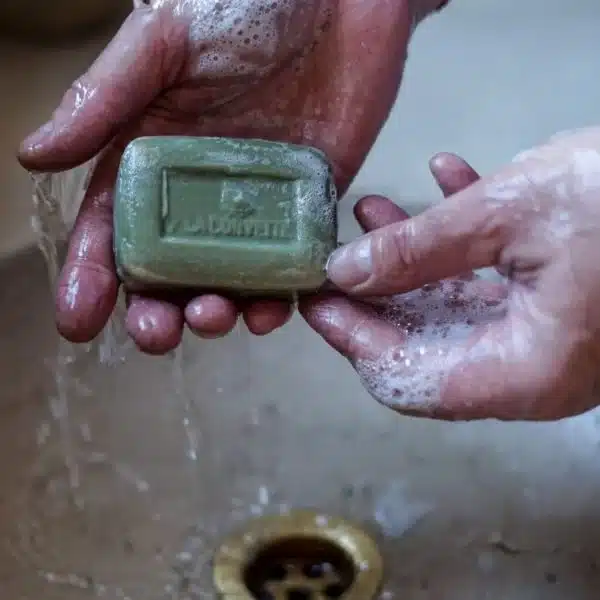 Une personne se lave les mains avec le savon Savon de Marseille Olive dans un évier.