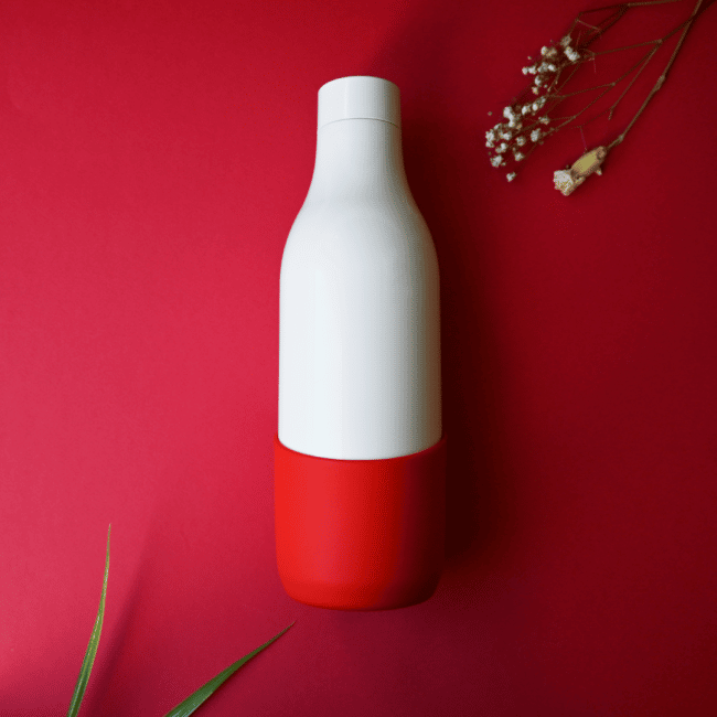 Une Gourde Française Personnalisable - Bouteille d'eau française rouge et blanche de 50 cl sur une surface rouge.
