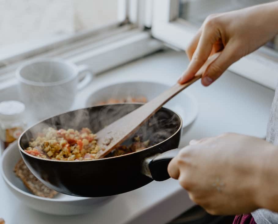 person holding black frying pan