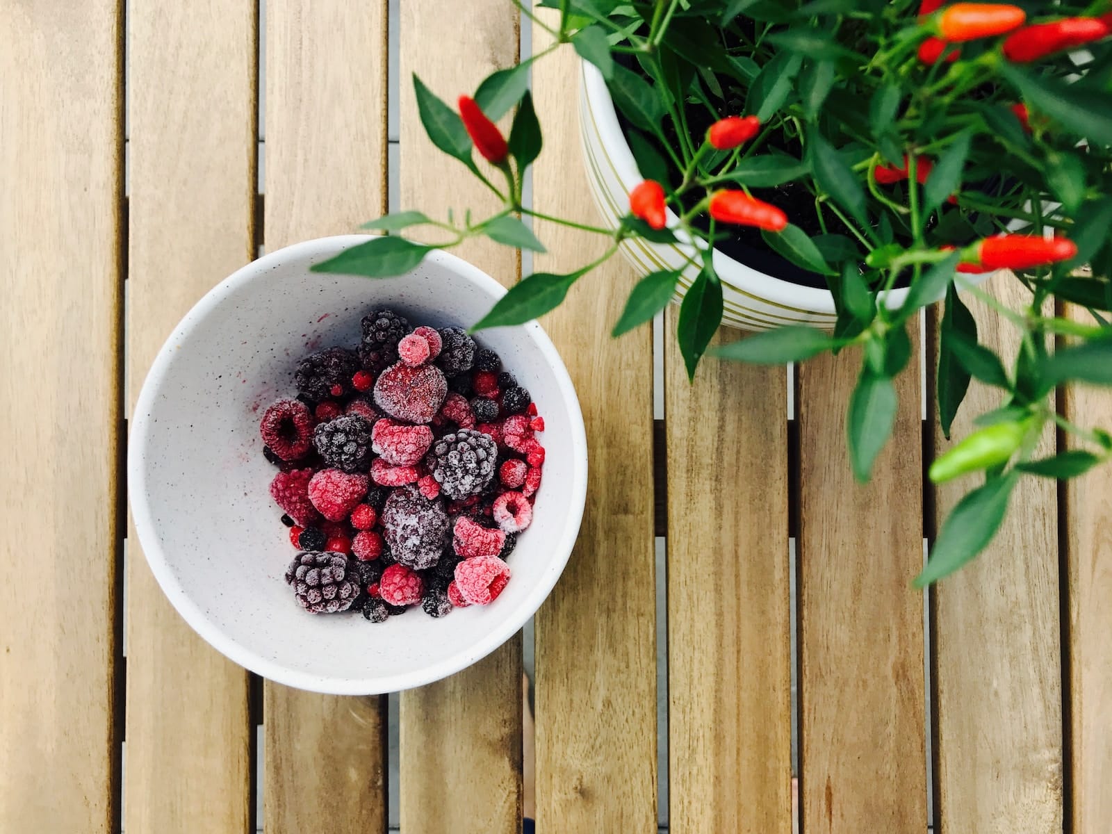 raspberries and black berries in white ceramic bowl