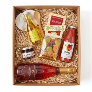 Visuel d'un coffret en kraft, rempli de frisures et quelques produits : huile d'olive, bonbons, jus de fruit, confiture